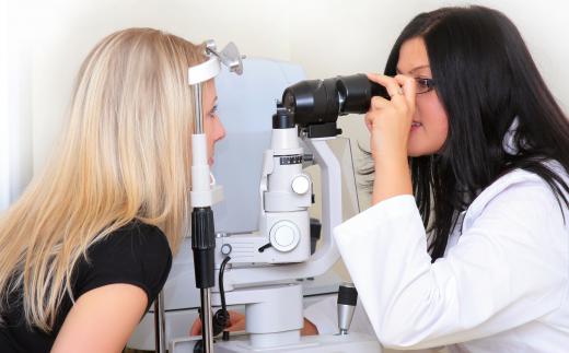 An optometrist examining a woman to see if she needs glasses.