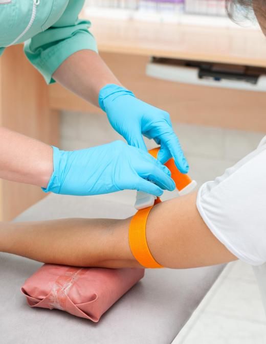 A tourniquet will be placed around a patient's arm by a medical professional before inserting an intravenous cannula.